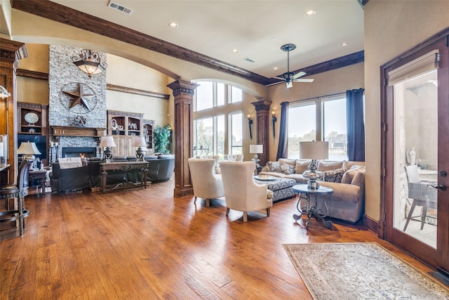living room featuring visible vents, ornamental molding, ornate columns, and a ceiling fan