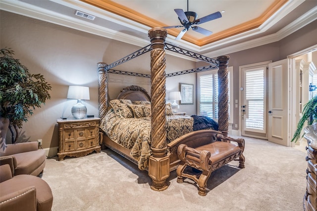 carpeted bedroom featuring a ceiling fan, access to outside, visible vents, a raised ceiling, and ornamental molding
