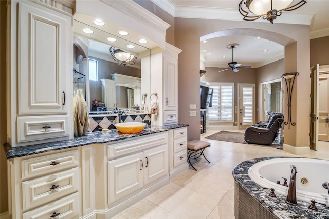 full bathroom featuring ceiling fan, ornamental molding, a tub with jets, and a wealth of natural light