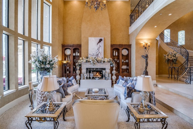 living room featuring a healthy amount of sunlight, a high end fireplace, and a towering ceiling