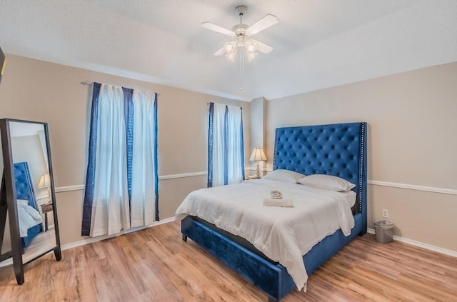 bedroom featuring ceiling fan, wood finished floors, and baseboards