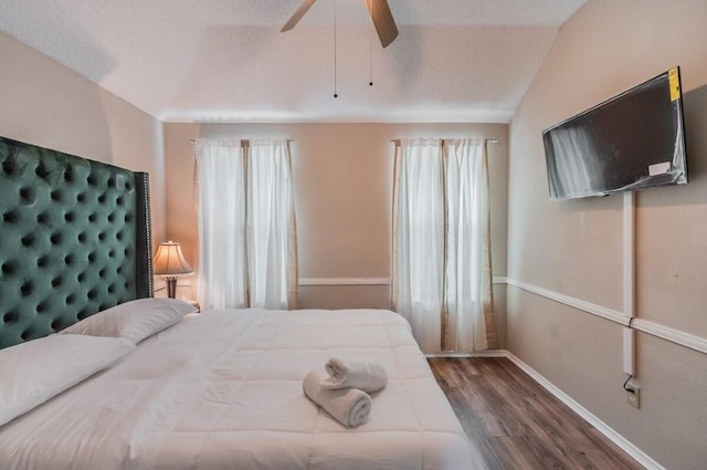 bedroom with lofted ceiling, wood finished floors, ceiling fan, and baseboards