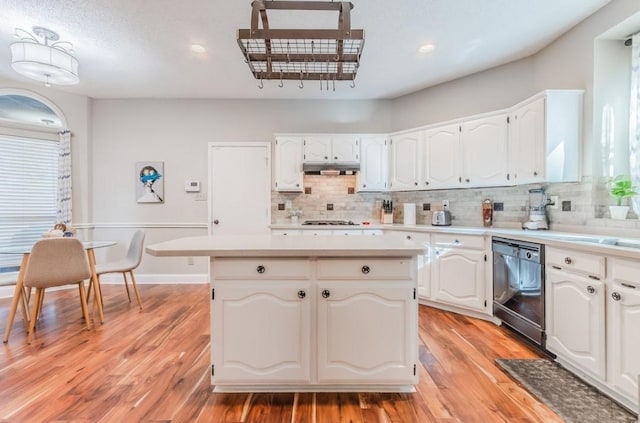 kitchen featuring tasteful backsplash, a center island, black dishwasher, and white cabinets