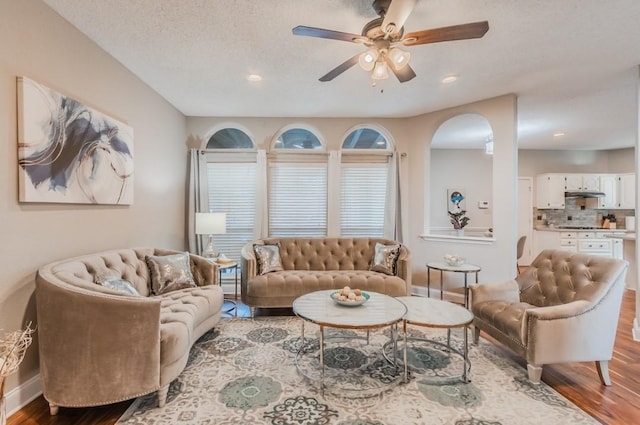 living area with wood finished floors, ceiling fan, recessed lighting, and baseboards