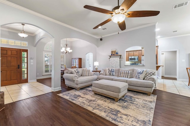 living room featuring visible vents, light wood-style flooring, and ceiling fan with notable chandelier