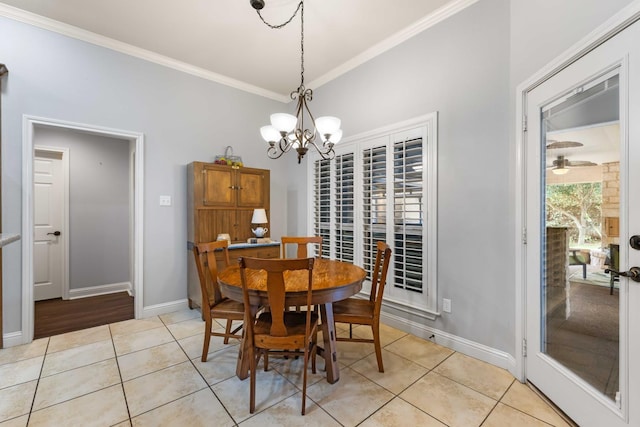 dining area with light tile patterned floors, a chandelier, ornamental molding, and baseboards