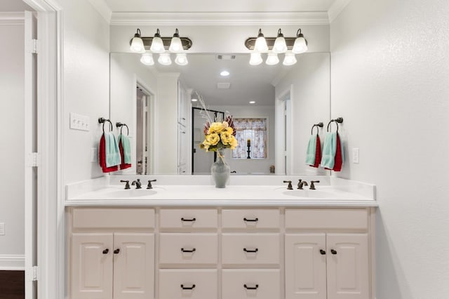 bathroom with ornamental molding, double vanity, and a sink
