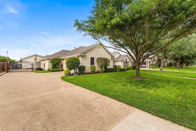 ranch-style home with a front yard, fence, stone siding, and a gate