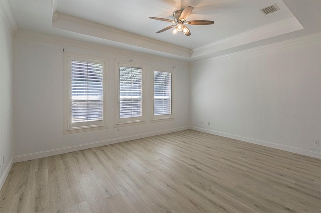 unfurnished room featuring a healthy amount of sunlight, ceiling fan, and a tray ceiling