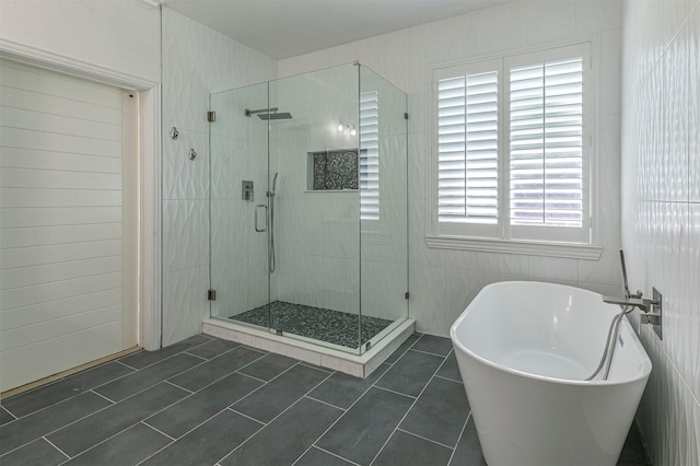 bathroom featuring a soaking tub, tile patterned floors, and a shower stall