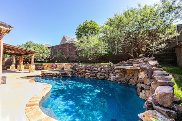view of pool with a pool with connected hot tub, a patio, and a fenced backyard