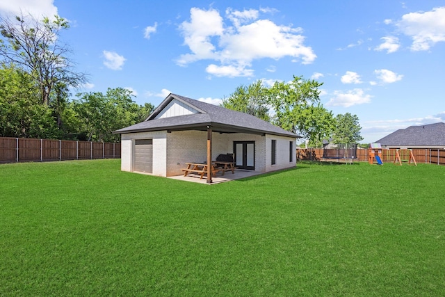 2214 Norwood St, Sherman, TX 75092 - back of house with a lawn, a trampoline, and a fenced backyard