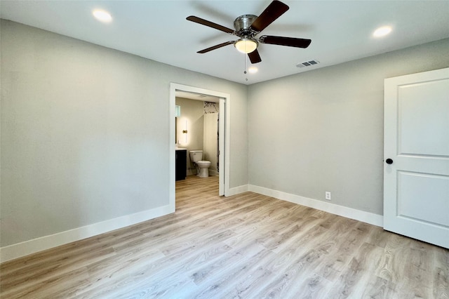 unfurnished bedroom with recessed lighting, baseboards, light wood-type flooring, and ensuite bath