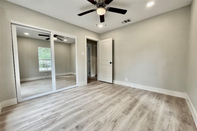 unfurnished bedroom with baseboards, ceiling fan, wood finished floors, and visible vents