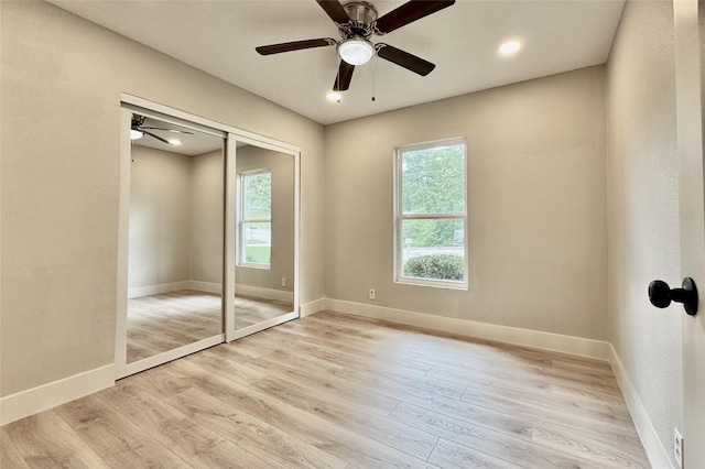 unfurnished bedroom featuring light wood finished floors, a ceiling fan, baseboards, recessed lighting, and a closet