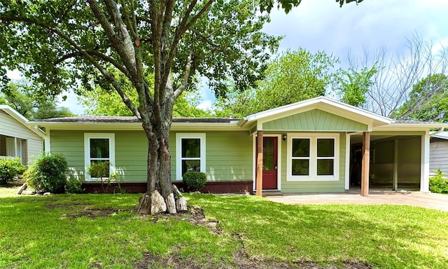ranch-style house featuring an attached carport, driveway, and a front yard