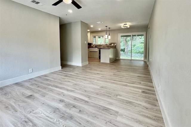 unfurnished living room with baseboards, a ceiling fan, light wood-style flooring, and visible vents