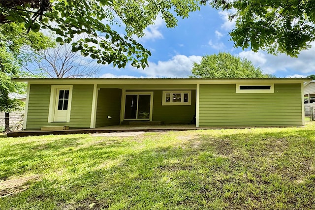 back of house featuring a lawn and a patio area