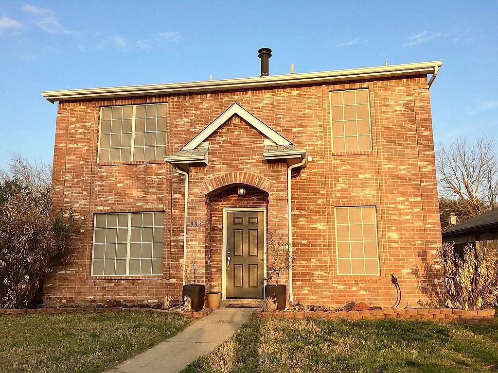 traditional home featuring brick siding and a front yard