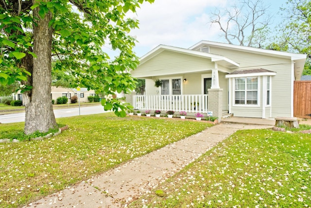1301 N Sylvania Ave, Fort Worth, TX 76111 - bungalow-style home with fence, covered porch, and a front lawn