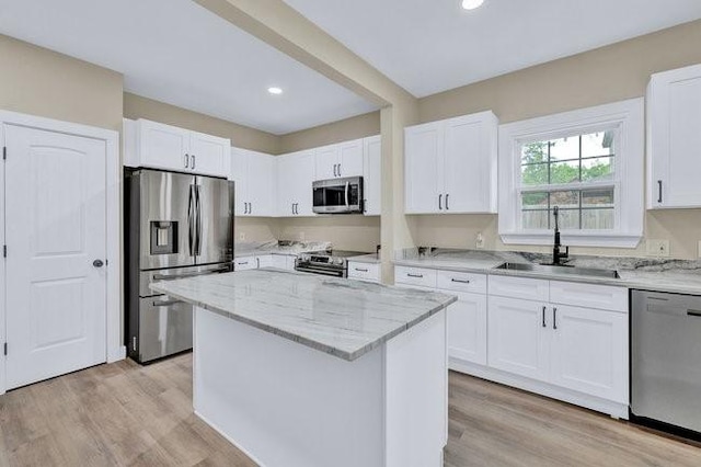 1301 N Sylvania Ave, Fort Worth, TX 76111 - kitchen with light stone counters, white cabinets, a sink, appliances with stainless steel finishes, and a center island