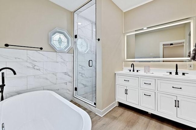 1301 N Sylvania Ave, Fort Worth, TX 76111 - full bath with wood finished floors, a freestanding bath, a shower stall, double vanity, and a sink