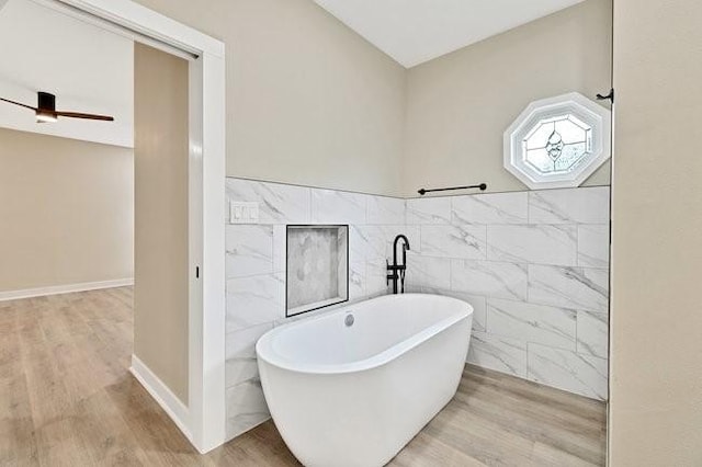 1301 N Sylvania Ave, Fort Worth, TX 76111 - full bath featuring tile walls, a freestanding bath, ceiling fan, and wood finished floors