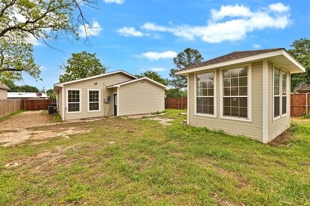 1301 N Sylvania Ave, Fort Worth, TX 76111 - rear view of house with a fenced backyard, a yard, and an outdoor structure