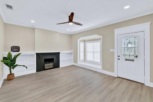 1301 N Sylvania Ave, Fort Worth, TX 76111 - interior space featuring wood finished floors, ceiling fan, a fireplace, visible vents, and crown molding