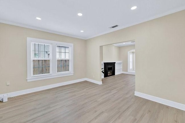 1301 N Sylvania Ave, Fort Worth, TX 76111 - unfurnished living room featuring visible vents, light wood-type flooring, crown molding, and baseboards