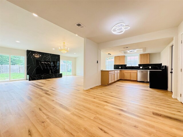 kitchen featuring light wood finished floors, a chandelier, light brown cabinets, visible vents, and open floor plan