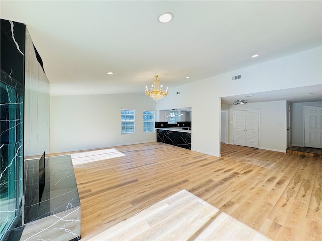 409 Bodart Ln, Fort Worth, TX 76108 - unfurnished living room with a chandelier, light wood finished floors, and recessed lighting