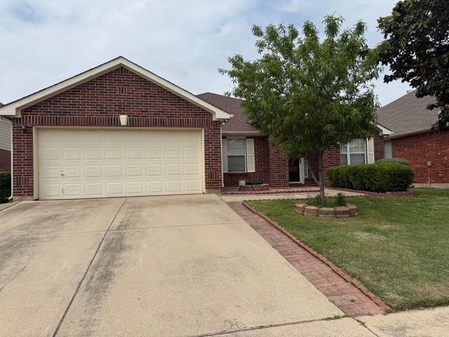 ranch-style house with brick siding, a front lawn, driveway, and an attached garage