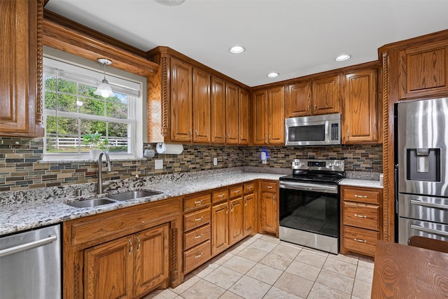 kitchen with appliances with stainless steel finishes, light tile patterned floors, decorative backsplash, and a sink
