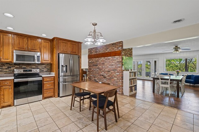 kitchen with light tile patterned floors, tasteful backsplash, stainless steel appliances, and light countertops