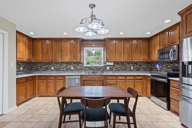 kitchen with an inviting chandelier, decorative backsplash, light tile patterned floors, stainless steel appliances, and a sink