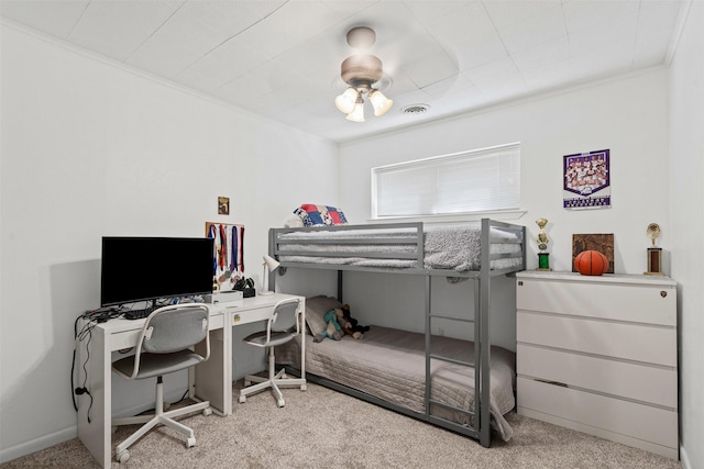 carpeted bedroom featuring visible vents, a ceiling fan, and crown molding
