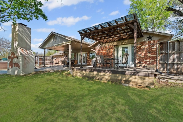 back of property featuring fence, a yard, and brick siding
