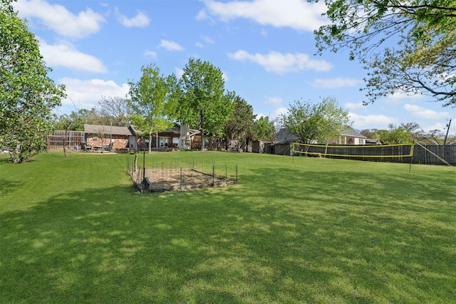 view of yard with volleyball court and fence