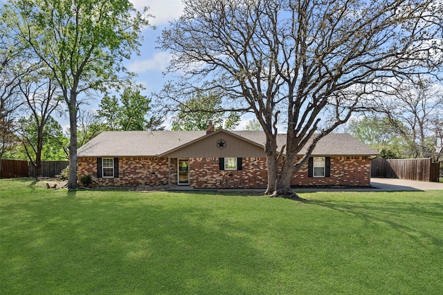 exterior space featuring fence, a lawn, and brick siding