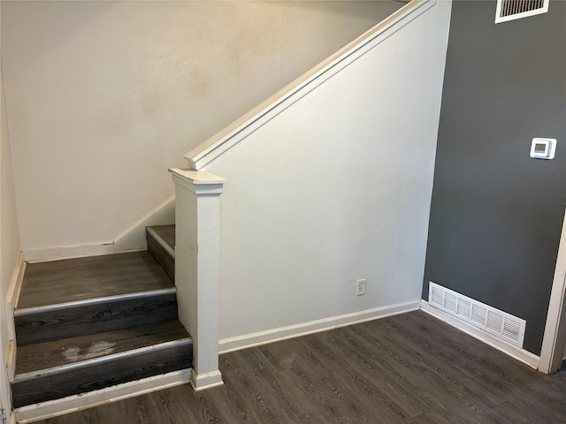 stairs featuring wood finished floors, visible vents, and baseboards