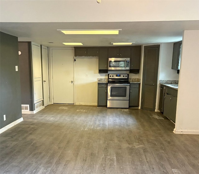 kitchen featuring visible vents, baseboards, light countertops, appliances with stainless steel finishes, and dark wood finished floors