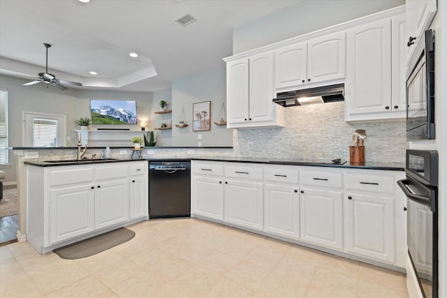 kitchen featuring a sink, visible vents, dark countertops, black appliances, and a peninsula