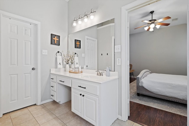 ensuite bathroom featuring tile patterned flooring, ceiling fan, ensuite bathroom, vanity, and baseboards