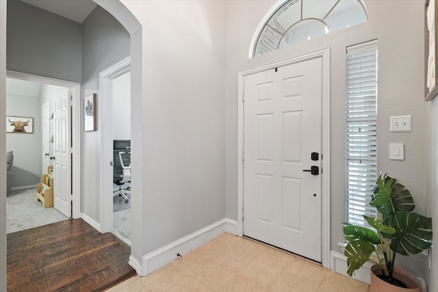 entrance foyer featuring arched walkways and baseboards