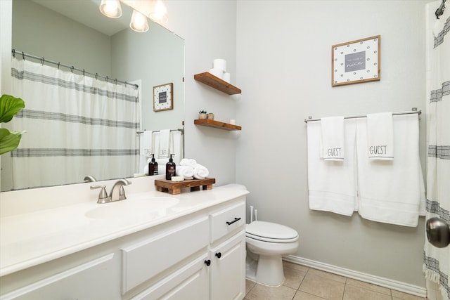 bathroom with toilet, vanity, tile patterned floors, and baseboards