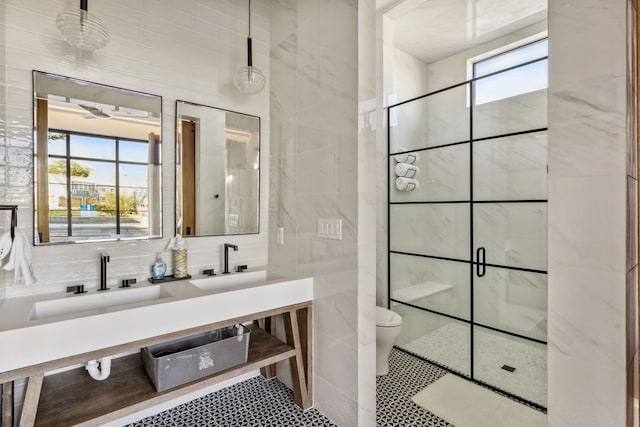 full bath featuring toilet, a stall shower, tile walls, and vanity