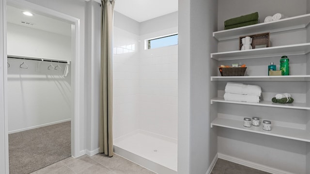 full bath with visible vents, a stall shower, baseboards, tile patterned floors, and a spacious closet