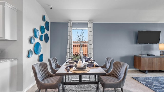 dining space featuring light tile patterned floors and baseboards