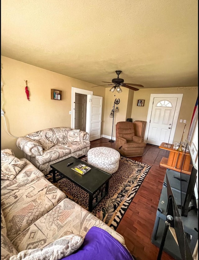 living area featuring a textured ceiling, wood finished floors, and a ceiling fan